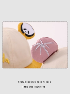 Dettaglio delle orecchie di panda 3D e del ricamo di bambù su un cappello beige da bimbi