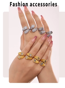 Detail of stacked snake-textured rings with colorful cubic zirconia on polished gold base