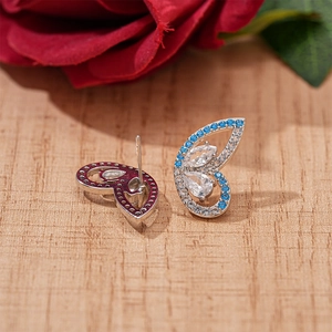 Exquisite silver butterfly stud earrings with blue and white zircons on wooden surface