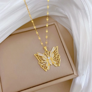 Macro view of gold hollow butterfly pendant with sparkling rhinestones and fine chain