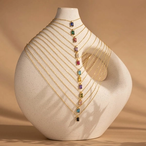 18K gold plated necklace with rectangular colorful birthstone pendants on a ceramic stand