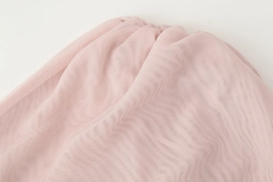 Close-up of pink mesh fabric with elegant pleated texture for one shoulder blouse