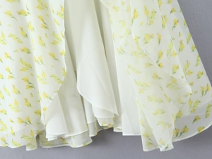 Dettaglio dell'orlo del vestito in chiffon a fiori gialli con fodera interna bianca