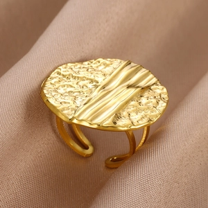 Macro detail of golden irregular lava texture ring with adjustable open band design