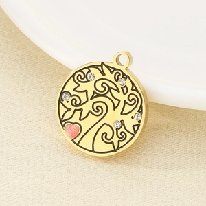 Macro view of gold stainless steel Tree of Life pendant with rhinestones and pink heart