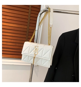 Close-up of white PU leather bag with geometric quilting and gold SS hardware with tassel