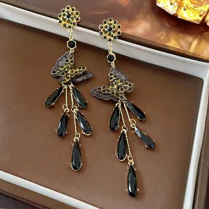 Elegant gold bow earrings with black crystal drop tassels and intricate flower studs
