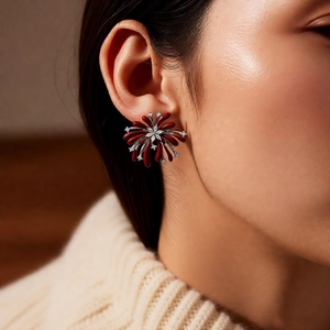 Macro detail of vintage red firework stud earring with zircons worn by a model