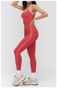 Close-up of red yoga jumpsuit with white contrast piping and high-stretch athletic fabric