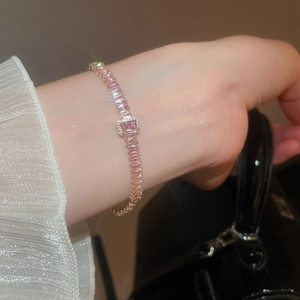 Primo piano di un bracciale tennis con gemma rosa rettangolare e zirconi incastonati