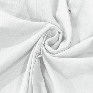 Dettaglio macro del tessuto in cotone e lino bianco con bottoni in resina sulla camicia