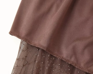 Détail du tissu en maille pailletée mocha et coutures sur un pantalon large chic