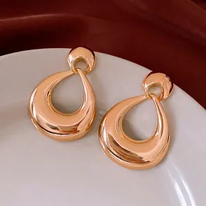 Polished gold teardrop hoop earrings with high mirror finish in retro luxury fashion style