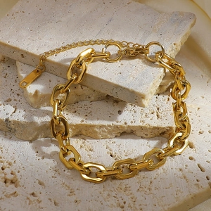 Detailed view of gold plated titanium steel chain bracelet on natural stone decor