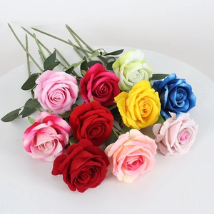 Artificial velvet roses in multiple colors on white table for home and wedding decor
