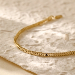 Macro detail of 14K gold plated box chain bracelet with elegant metallic luster
