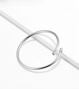 Detail view of a 3mm polished S925 sterling silver minimalist open bangle on a white platform
