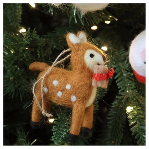 Detail of a handmade brown wool felt reindeer ornament hanging on a Christmas tree
