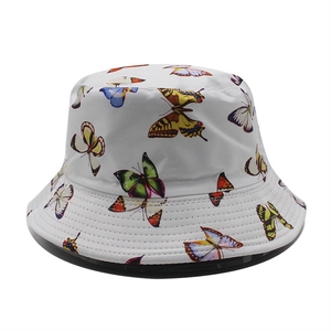 Detail of multi-colored butterfly print on a white cotton bucket hat with parallel stitching