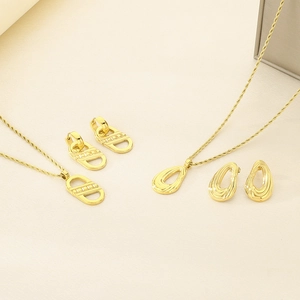 Detail view of two gold titanium jewelry sets with geometric pendants and twisted chains