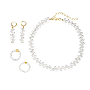 Minimalist jewelry set with irregular pearl necklace, gold earrings, and rings on white back