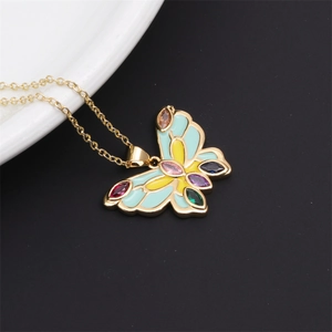 Detail of a gold butterfly necklace with blue and yellow enamel and colorful marquise stones