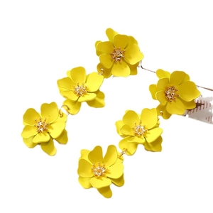 Vibrant yellow matte layered flower drop earrings with golden pistils on white background