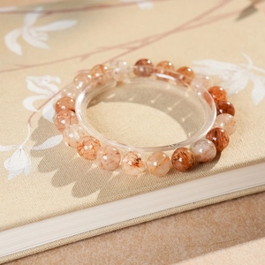 Macro shot of natural red rutilated quartz beads on a textured vintage notebook