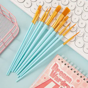 Set of 10 blue handle nylon paint brushes with various tips on a creative desk setup