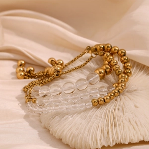Macro shot of 18K gold plated steel beads and clear acrylic charms on adjustable bracelet