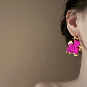 Elegant rose pink flower stud earrings with golden branch details on female model