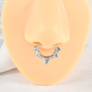 Macro view of silver U-shaped septum ring with spikes on a silicone nose model