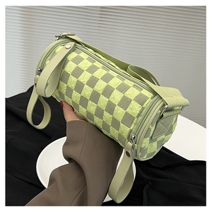 Detail of checkered barrel crossbody bag with green pleated texture and wide strap