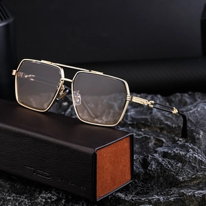 Retro pilot sunglasses with gold metal frames and brown gradient lenses on a leather case