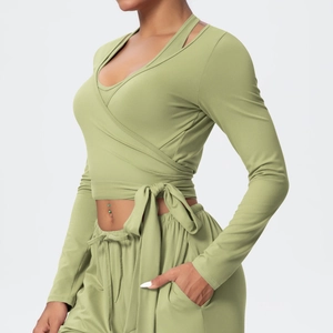 Detailed view of wrap-style yoga top with side tie and sage green high-stretch fabric