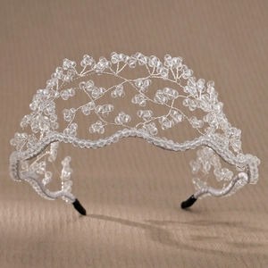 Macro detail of hand-woven crystal bridal headband with silver wire and white fabric wrap