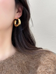 Minimalist gold-plated thick hoop earrings for women shown on model side profile view