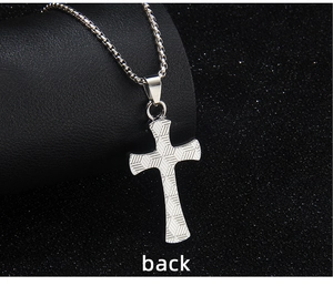 Macro detail of the engraved geometric texture on the back of the silver cross pendant