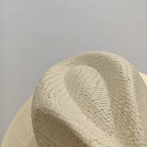 Macro shot of fine woven texture and detailed straw stitching on the ivory sun hat