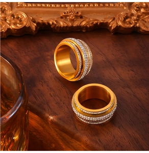 Macro shot of rotating triple-row crystal bands on a gold-plated titanium ring