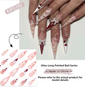 Macro view of cherry pink stiletto press-on nails with 3D bows and heart patterns