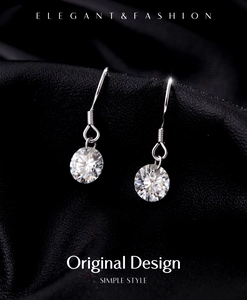 Détail macro de boucles d'oreilles moissanite 1ct sur fond noir texturé élégant