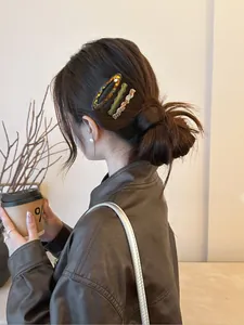 Close-up of tortoise shell and pastel acetate hair clips on model's hair side view