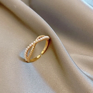 Detail of gold-plated crisscross ring with micro pearls and sparkling zircon stones
