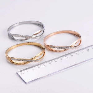 Close-up of three Roman numeral bangles in gold, silver, and rose gold with rhinestones