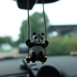 Detailed view of creative panda swing car charm hanging on a rearview mirror