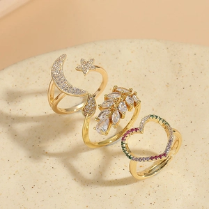 Detailed macro of gold-plated rings set featuring celestial star moon and leaf motifs