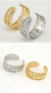 Detailed close-up of gold and silver wheat ear cutout rings on soft white faux fur