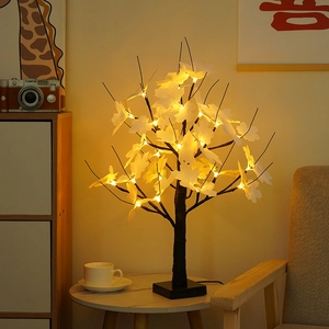 Close-up of lighted LED maple tree with white leaves and warm yellow glow for home decor