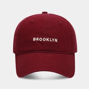 Close-up of white BROOKLYN letter embroidery on a premium burgundy cotton baseball cap
